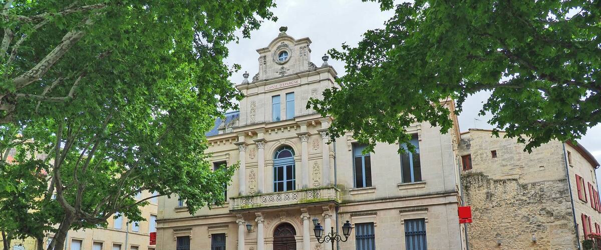 A historic building with ornate architecture, a clock tower, and a sign reading "Hôtel & Restaurant."
