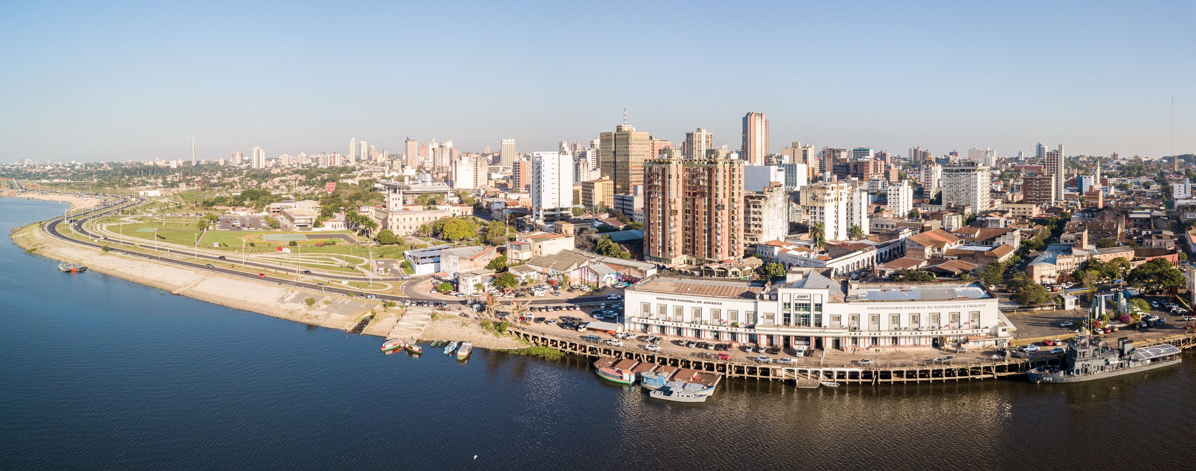 Panoramic view of skyscrapers skyline of Latin American capital of Asuncion city, Paraguay. Embankment of Paraguay river. Birds eye aerial drone photo. Ciudad de Asunción Paraguay.