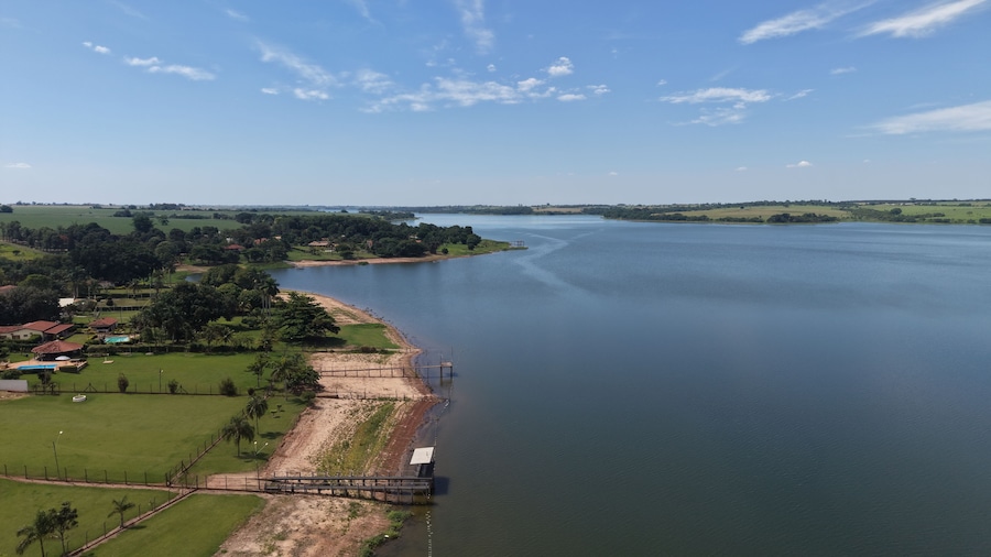 Une rivière traversée par un pont, des champs verdoyants et des bâtiments dispersés.
