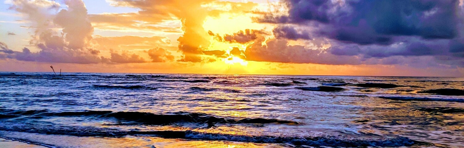 Un atardecer sobre el océano con olas en la orilla.
