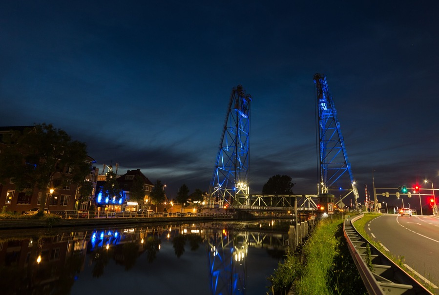 Vertical lift bridge of Waddinxveen, a town near the city of Gouda, Holland during blue hour. The bridge over the canal Gouwe is illuminated by blue light beams at night.