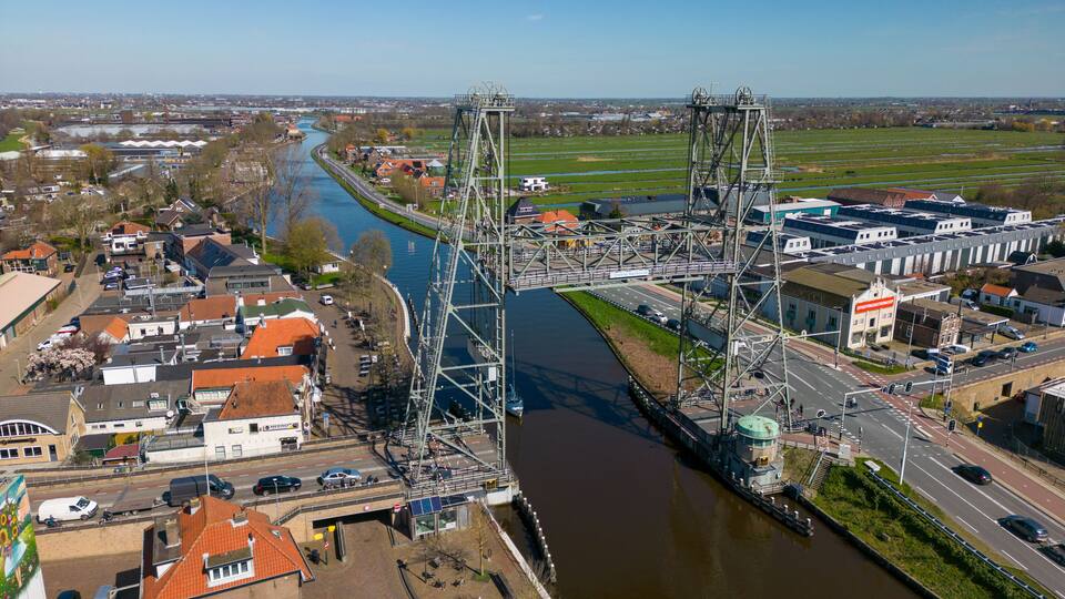 A bridge over a river with buildings and a road on either side.