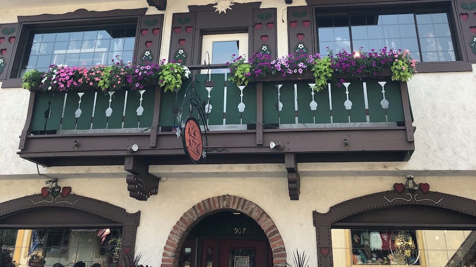 A building with a balcony adorned with flowers and heart-shaped decorations.