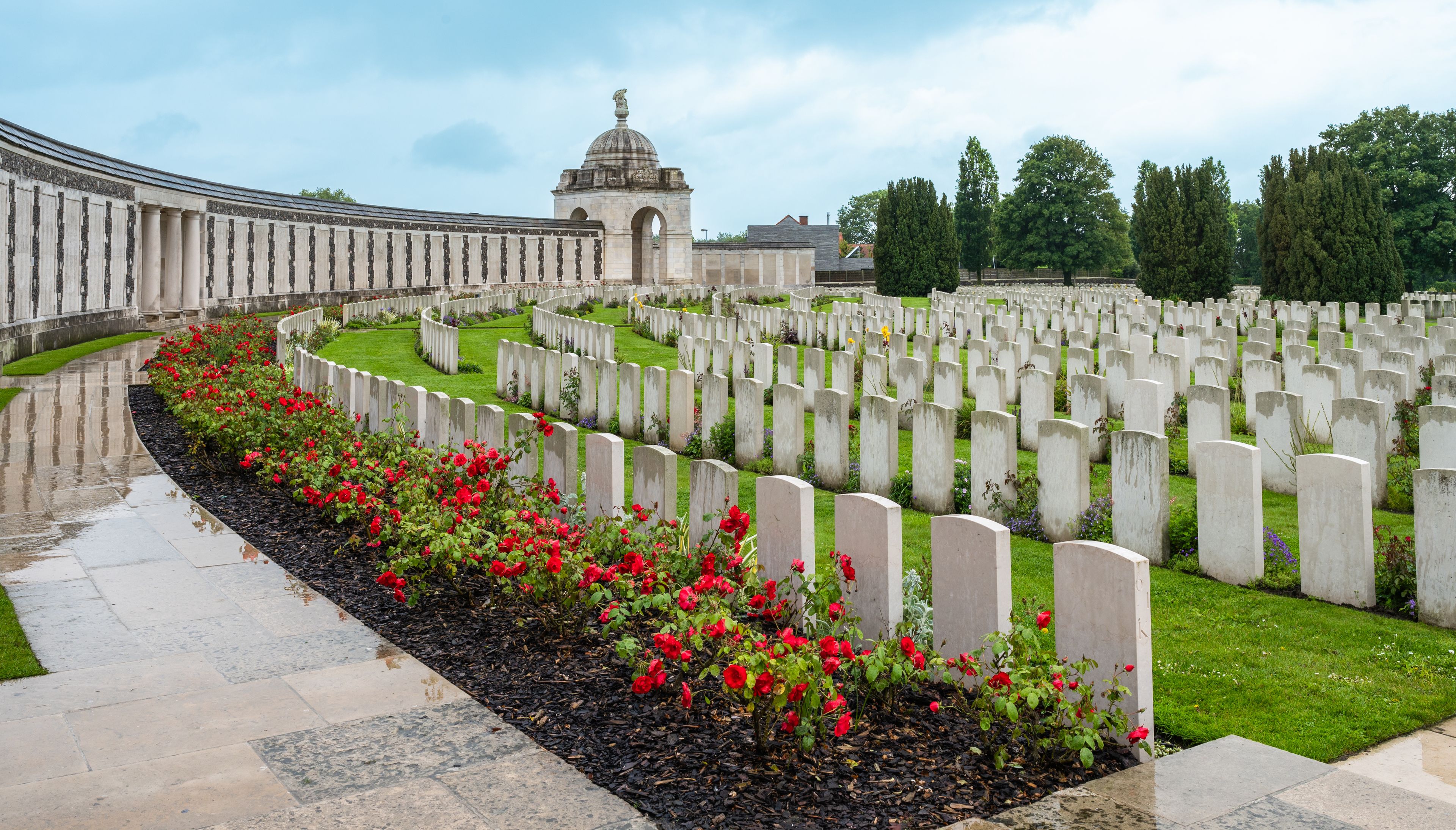 A cemetery with rows of headstones and a central monument.