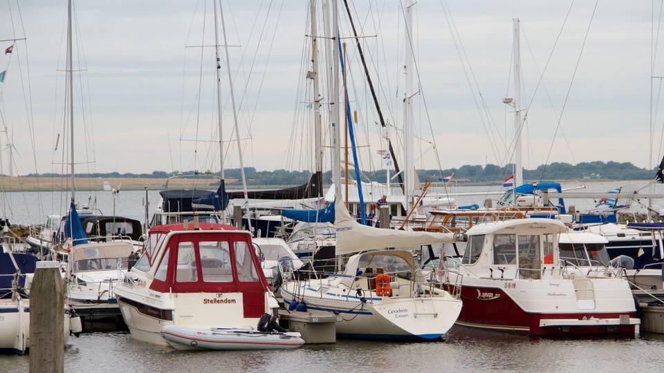 A marina with various boats docked, including a red and white boat named 'Stellendam' and a white boat named 'Goodwin Essen'.