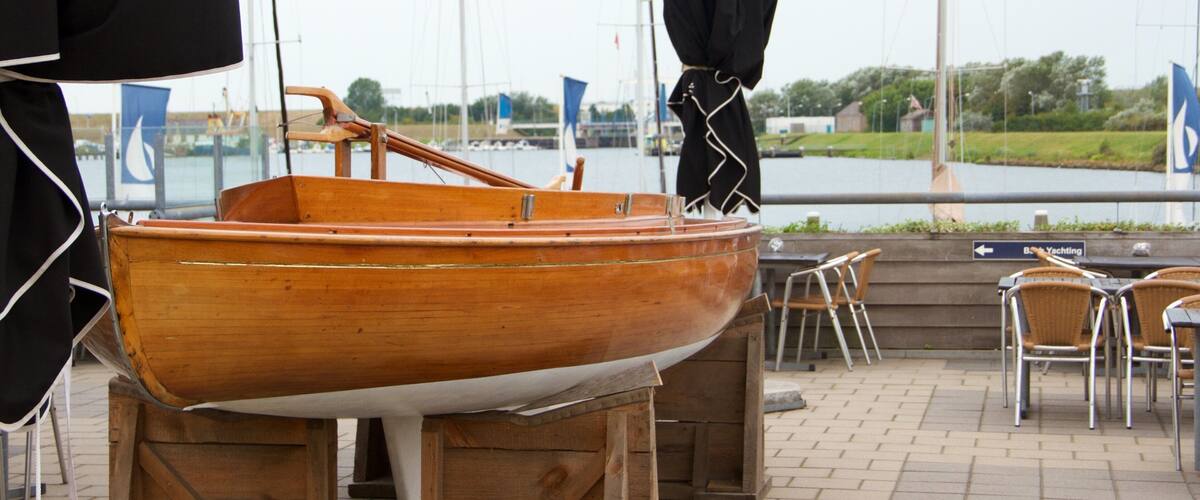A wooden boat on display, a waterfront view, and outdoor seating area.