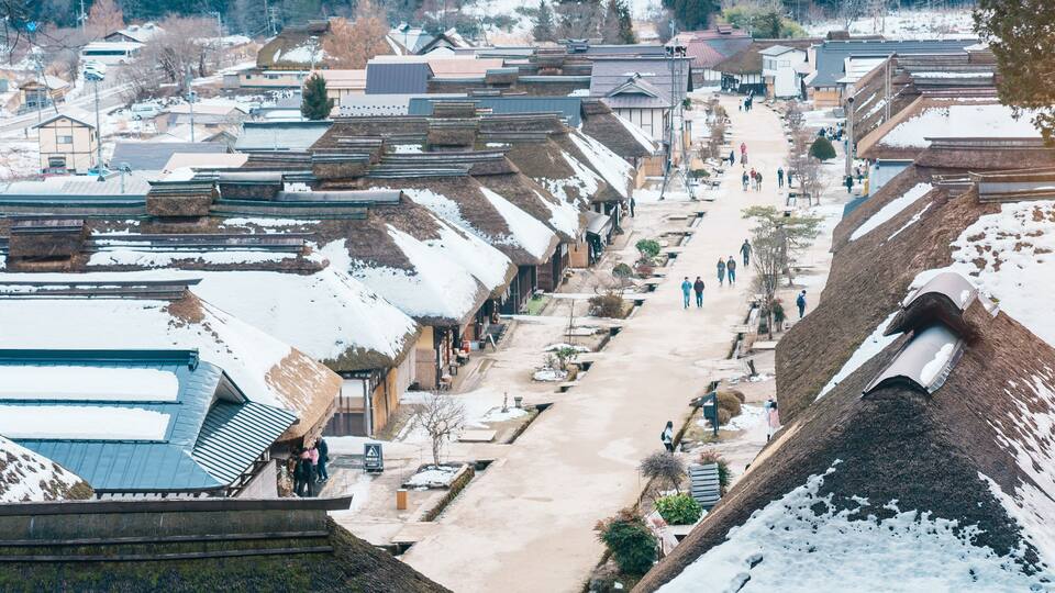 A snow-covered village with traditional houses and a central street.