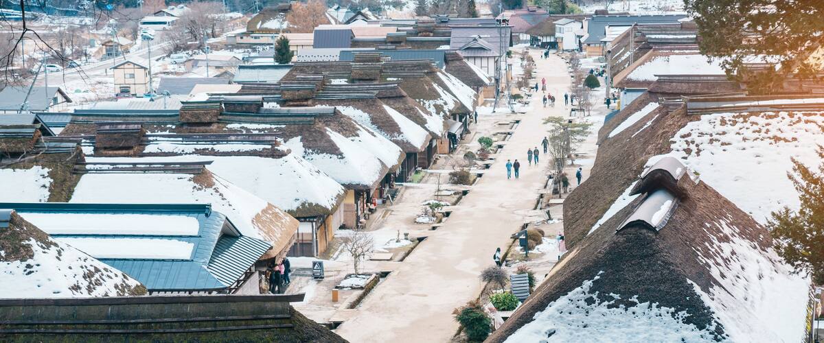 A snow-covered village with traditional houses and a central street.
