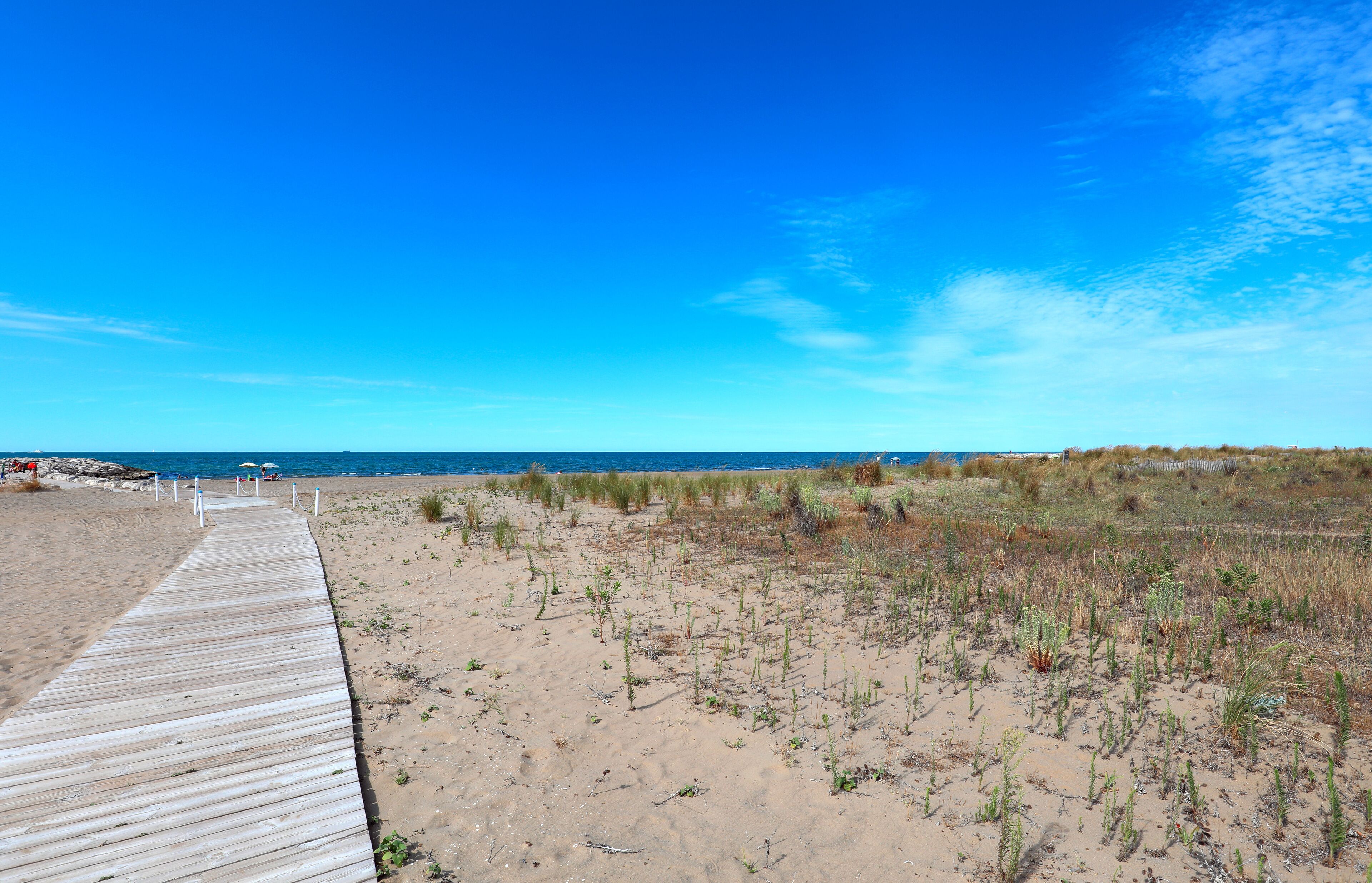 wooden walkway leading down to the crossing the sandy beach