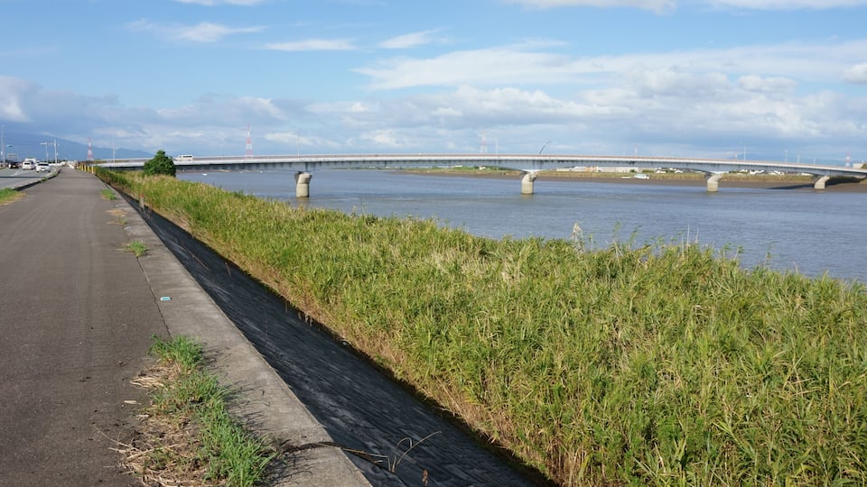 A bridge over a river with a road beside it.
