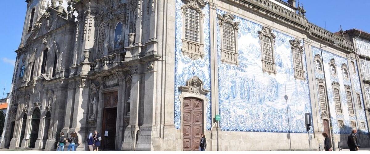 I thought this was just one church, but it is actually two connected by one of the world's narrowest houses - just 1 metre wide. 
To the left is Carmelitas Church, part of a former 17th century convent with a simple classical façade, a bell tower, and a richly gilded interior. 
To the right is Carmo Church, built later in the 18th century. It is a magnificent example of late baroque architecture with a single nave made up of elegant gilt carvings in seven altars by master Francisco Pereira Campanhã. 
Outside, an extraordinary side wall is completely covered in blue and white tile panels. 
The house that separates the two churches was inhabited until about 20 years ago. It was built due to a law that stated that no two churches could share a wall, while also ensuring chastity between the monks of Carmo and the nuns of Carmelitas.