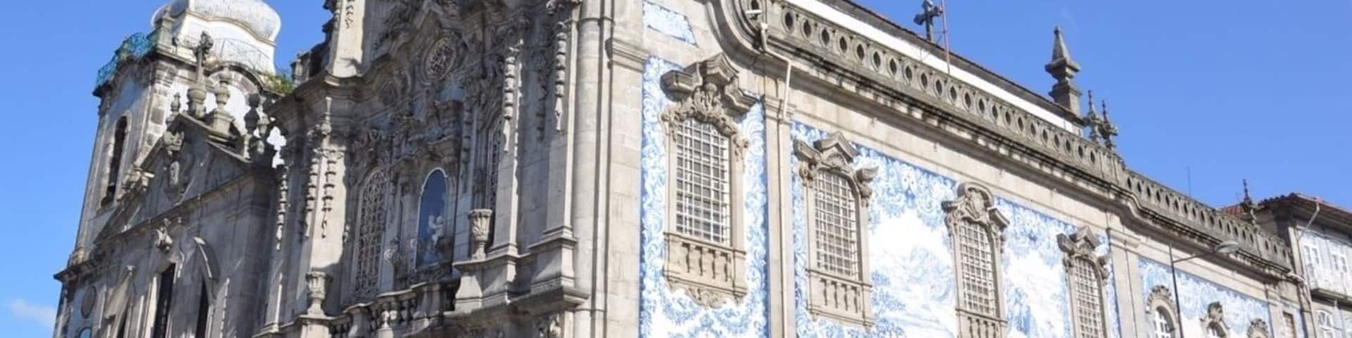 I thought this was just one church, but it is actually two connected by one of the world's narrowest houses - just 1 metre wide.
To the left is Carmelitas Church, part of a former 17th century convent with a simple classical façade, a bell tower, and a richly gilded interior.
To the right is Carmo Church, built later in the 18th century. It is a magnificent example of late baroque architecture with a single nave made up of elegant gilt carvings in seven altars by master Francisco Pereira Campanhã.
Outside, an extraordinary side wall is completely covered in blue and white tile panels.
The house that separates the two churches was inhabited until about 20 years ago. It was built due to a law that stated that no two churches could share a wall, while also ensuring chastity between the monks of Carmo and the nuns of Carmelitas.