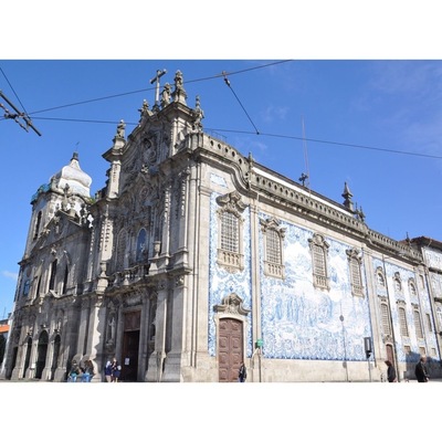 I thought this was just one church, but it is actually two connected by one of the world's narrowest houses - just 1 metre wide.
To the left is Carmelitas Church, part of a former 17th century convent with a simple classical façade, a bell tower, and a richly gilded interior.
To the right is Carmo Church, built later in the 18th century. It is a magnificent example of late baroque architecture with a single nave made up of elegant gilt carvings in seven altars by master Francisco Pereira Campanhã.
Outside, an extraordinary side wall is completely covered in blue and white tile panels.
The house that separates the two churches was inhabited until about 20 years ago. It was built due to a law that stated that no two churches could share a wall, while also ensuring chastity between the monks of Carmo and the nuns of Carmelitas.