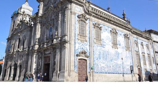 I thought this was just one church, but it is actually two connected by one of the world's narrowest houses - just 1 metre wide.
To the left is Carmelitas Church, part of a former 17th century convent with a simple classical façade, a bell tower, and a richly gilded interior.
To the right is Carmo Church, built later in the 18th century. It is a magnificent example of late baroque architecture with a single nave made up of elegant gilt carvings in seven altars by master Francisco Pereira Campanhã.
Outside, an extraordinary side wall is completely covered in blue and white tile panels.
The house that separates the two churches was inhabited until about 20 years ago. It was built due to a law that stated that no two churches could share a wall, while also ensuring chastity between the monks of Carmo and the nuns of Carmelitas.