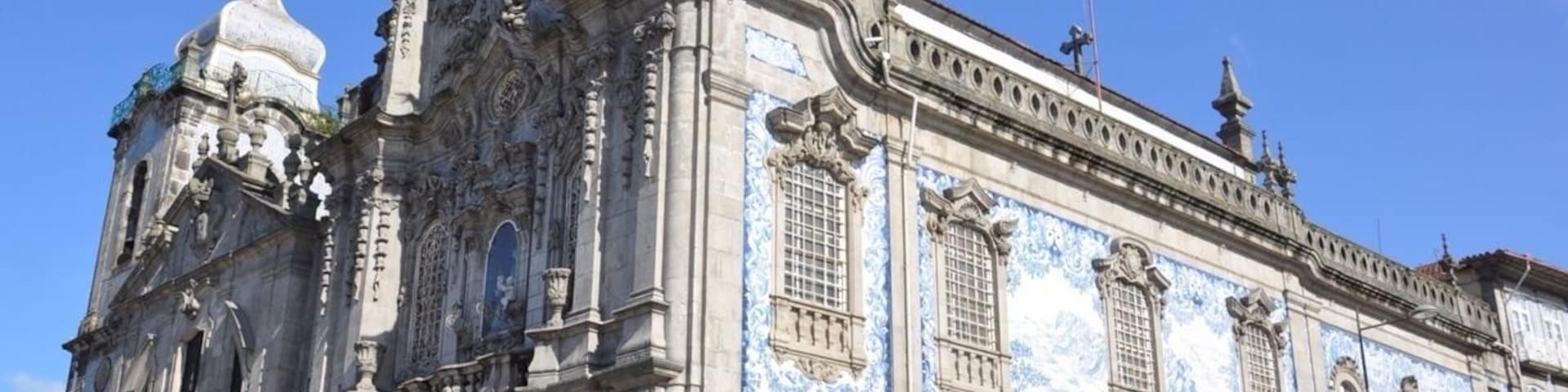 I thought this was just one church, but it is actually two connected by one of the world's narrowest houses - just 1 metre wide.
To the left is Carmelitas Church, part of a former 17th century convent with a simple classical façade, a bell tower, and a richly gilded interior.
To the right is Carmo Church, built later in the 18th century. It is a magnificent example of late baroque architecture with a single nave made up of elegant gilt carvings in seven altars by master Francisco Pereira CampanhĂŁ.
Outside, an extraordinary side wall is completely covered in blue and white tile panels.
The house that separates the two churches was inhabited until about 20 years ago. It was built due to a law that stated that no two churches could share a wall, while also ensuring chastity between the monks of Carmo and the nuns of Carmelitas.