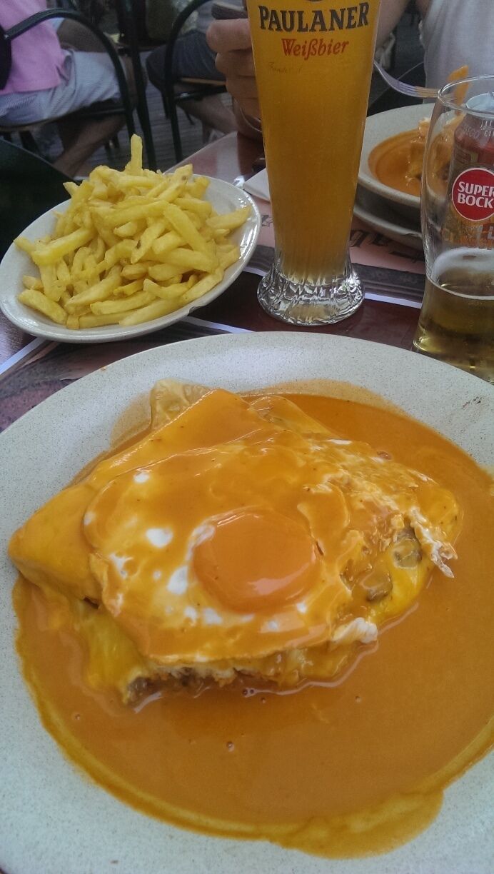 "Francesinha" is a Portuguese sandwich originally from Oporto, made with bread, wet-cured ham, linguiça, sausage, steak, egg and covered with melted cheese and a hot thick spicy tomato and beer sauce served with french fries. In the Taberna Belga in Braga is one of the bests I ever tried.
