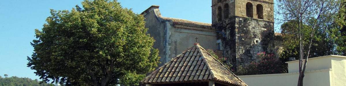 Une église dotée d’un clocher, de murs en pierre et d’un petit kiosque.