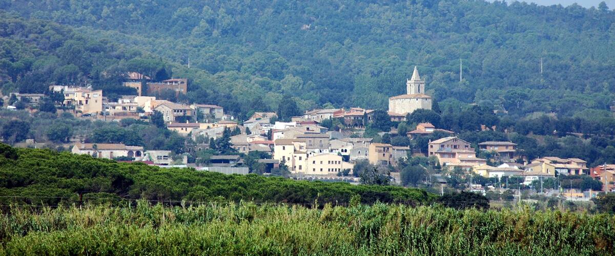 A hillside town with buildings and a church on a hill.