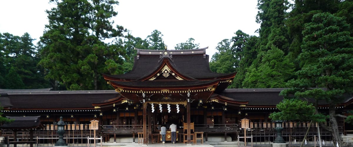 Un temple japonais traditionnel doté d’une cour dallée et de bancs en bois.