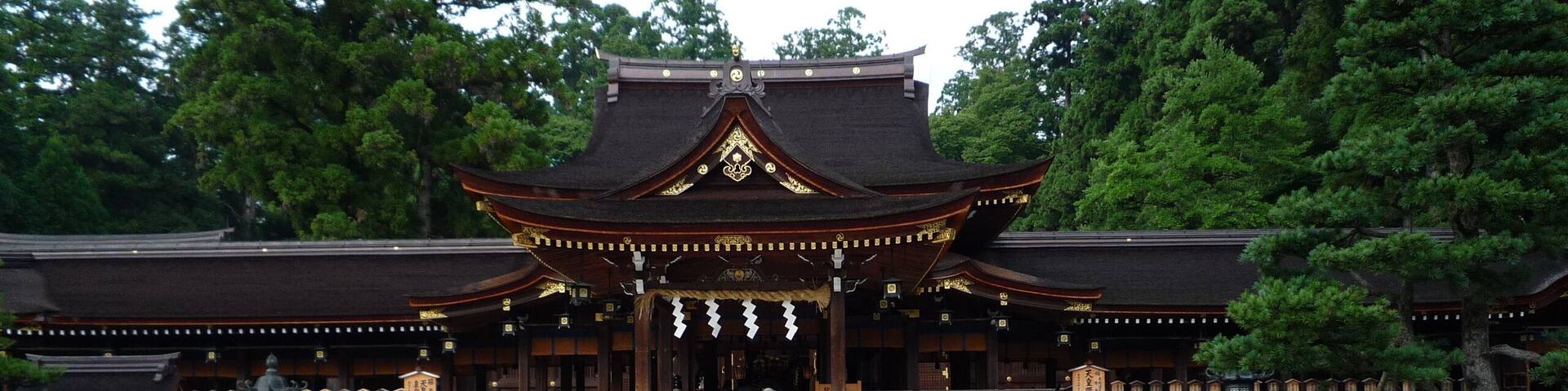 A traditional Japanese temple with a tiled courtyard and wooden benches.
