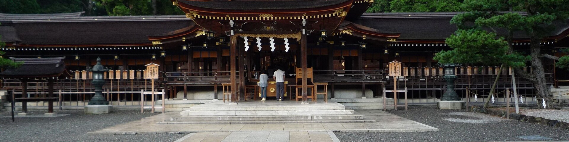 Un templo japonés tradicional con un patio de tejas y bancos de madera.