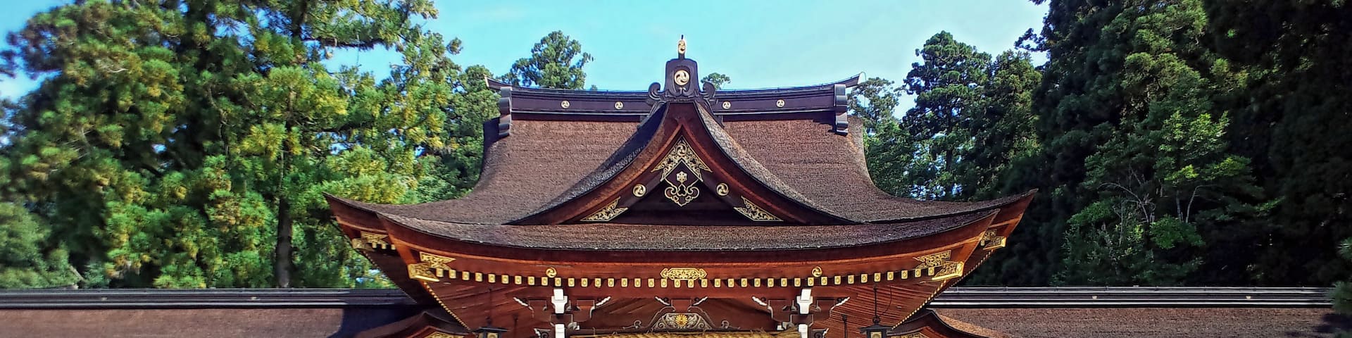 A traditional Japanese temple with a prominent golden roof and wooden structure.