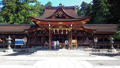 A traditional Japanese temple with a prominent golden roof and wooden structure.