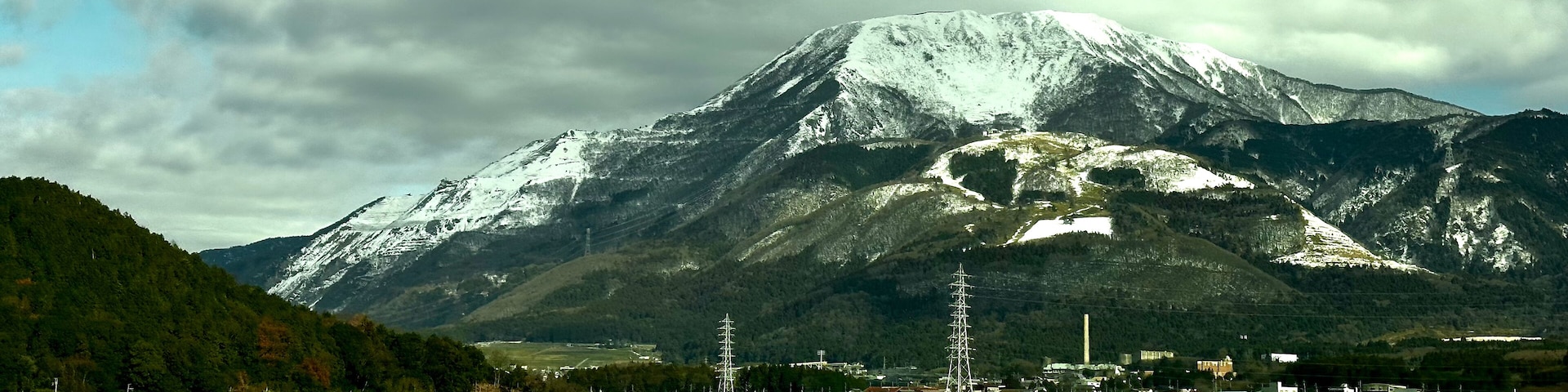 Una montaña nevada, un pueblo con casas y campos.