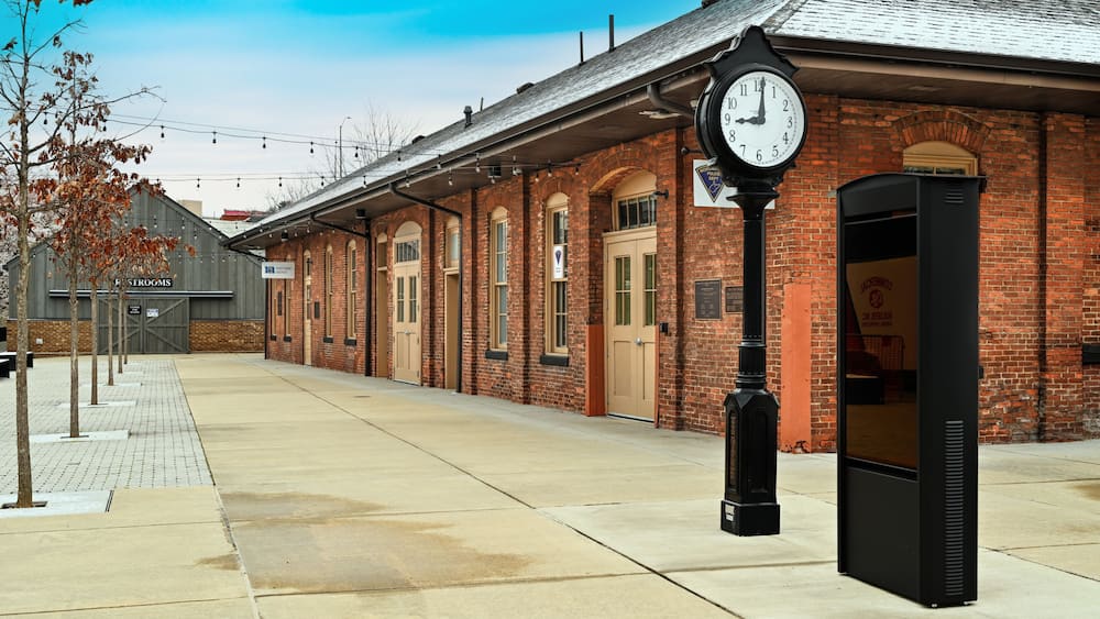 Un bùtiment en briques avec une horloge, un banc et une enseigne indiquant « Firesides ».