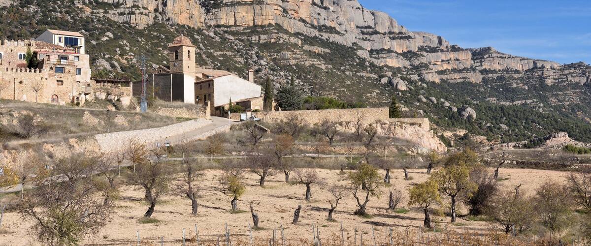A mountainous landscape with a stone building and a church.