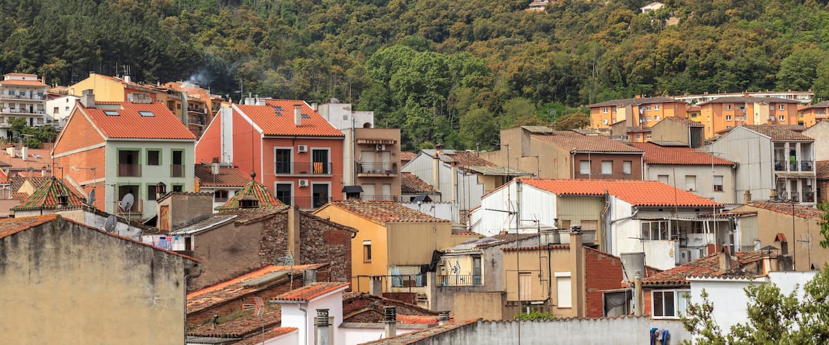 A town with colorful buildings and a mountain range in the background.