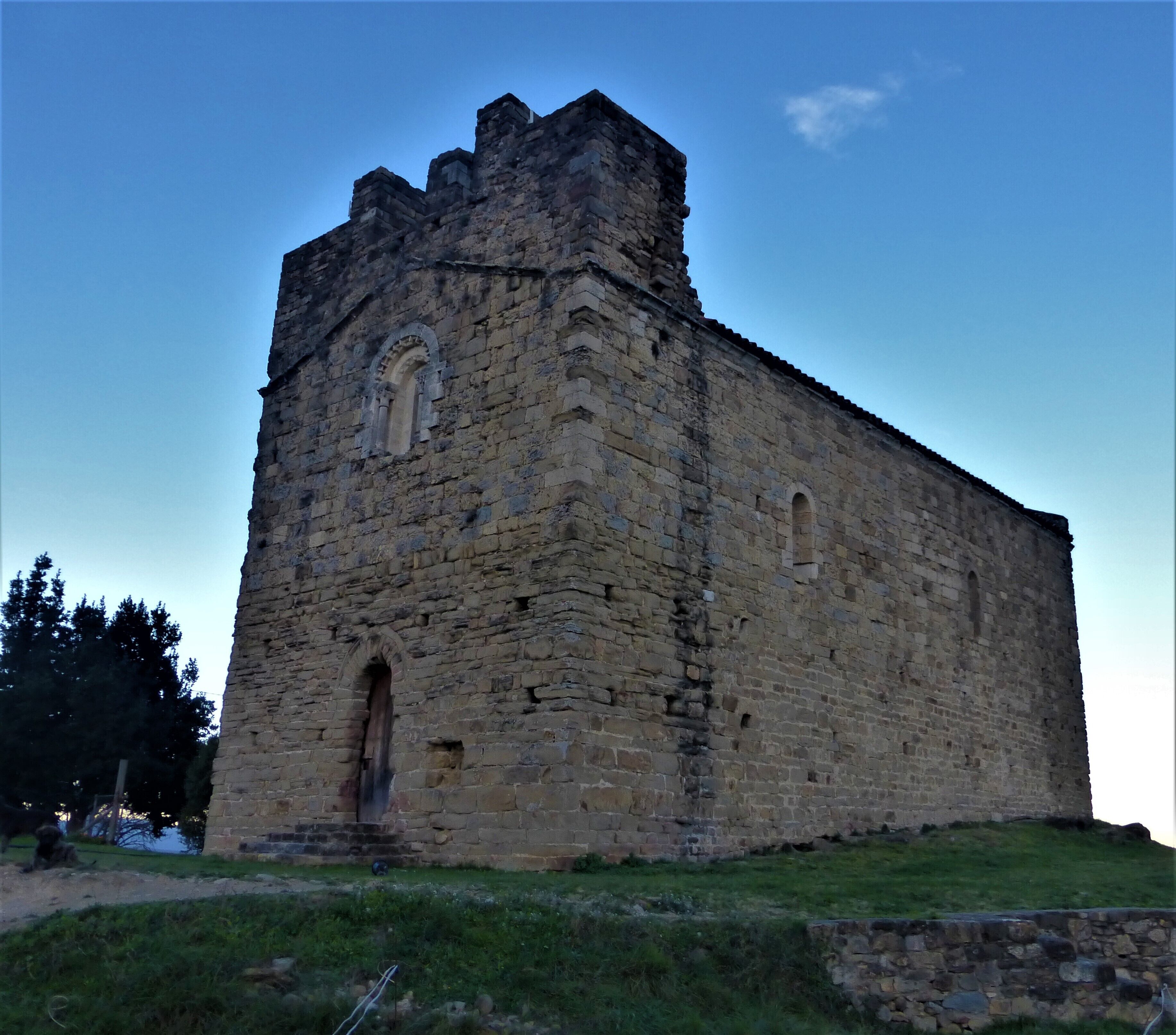 A large stone castle with a tall tower and arched windows.