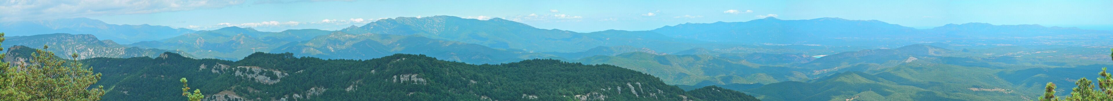 Panorama des del santuari del Mont mirant al nord; a l'esquerra entre els núvols el Canigó, a la dreta el Mediterrani