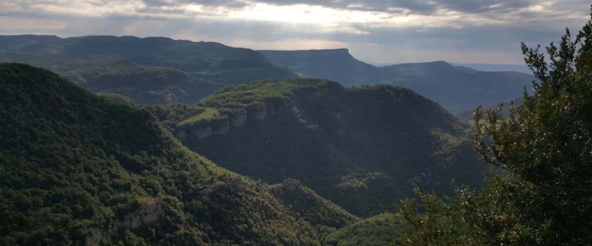 A mountainous landscape with lush green hills and a valley.