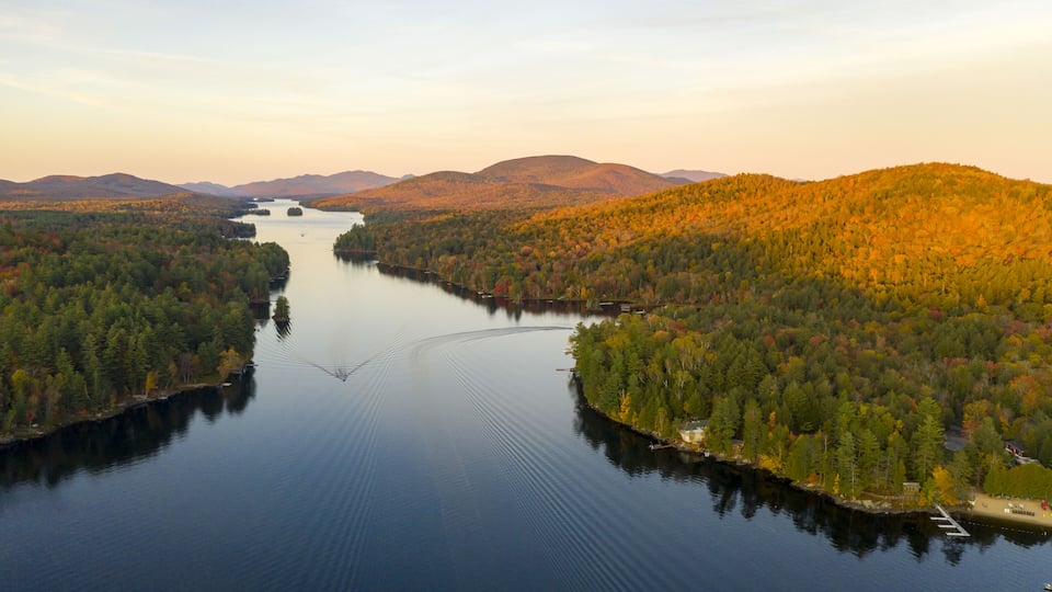 A calm lake surrounded by dense forests and mountains.
