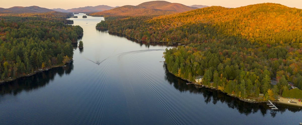 A calm lake surrounded by dense forests and mountains.
