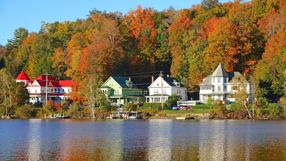 A lakeside village with colorful autumn foliage and houses with distinct architectural styles.