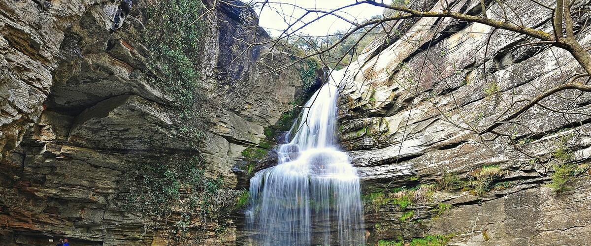 A waterfall cascading down a rocky cliff into a pool.