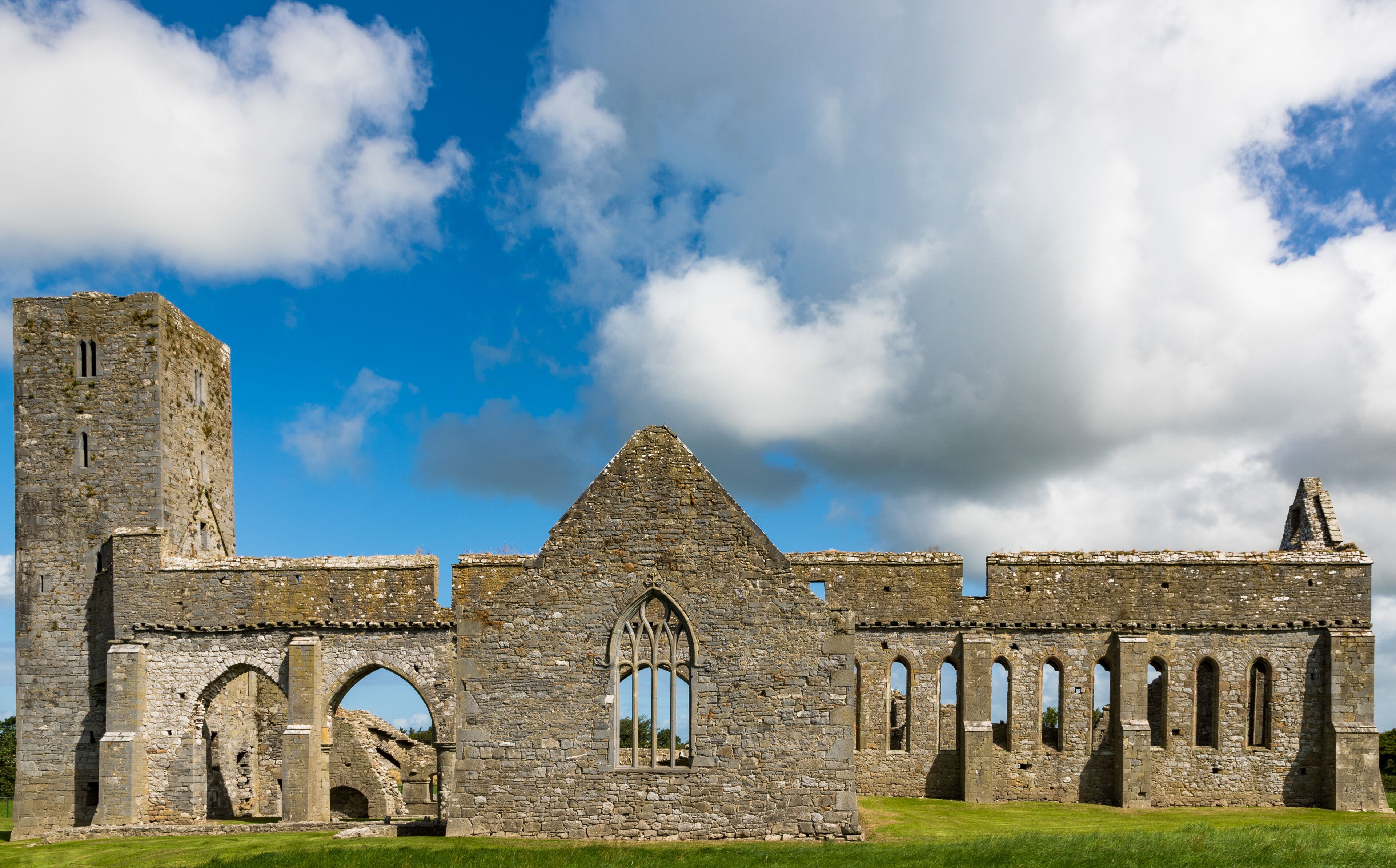 An ancient stone castle with arched windows and a prominent tower.