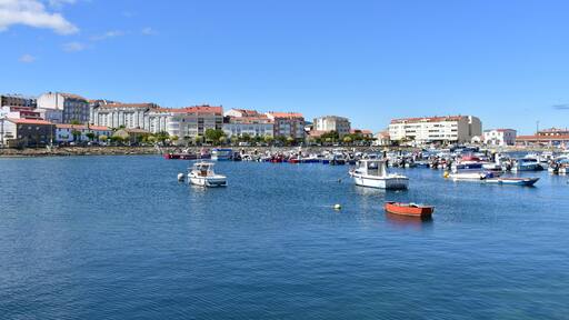 Harbour and coastal village with galician fishing vessels, rowboats and sailing boats at famous Rias Baixas in Galicia Region. Portosin, Coruña, Spain.