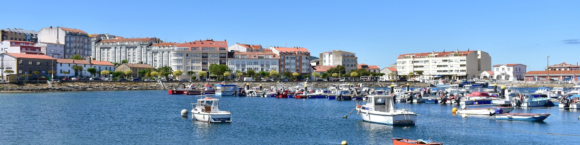 Harbour and coastal village with galician fishing vessels, rowboats and sailing boats at famous Rias Baixas in Galicia Region. Portosin, Coruña, Spain.