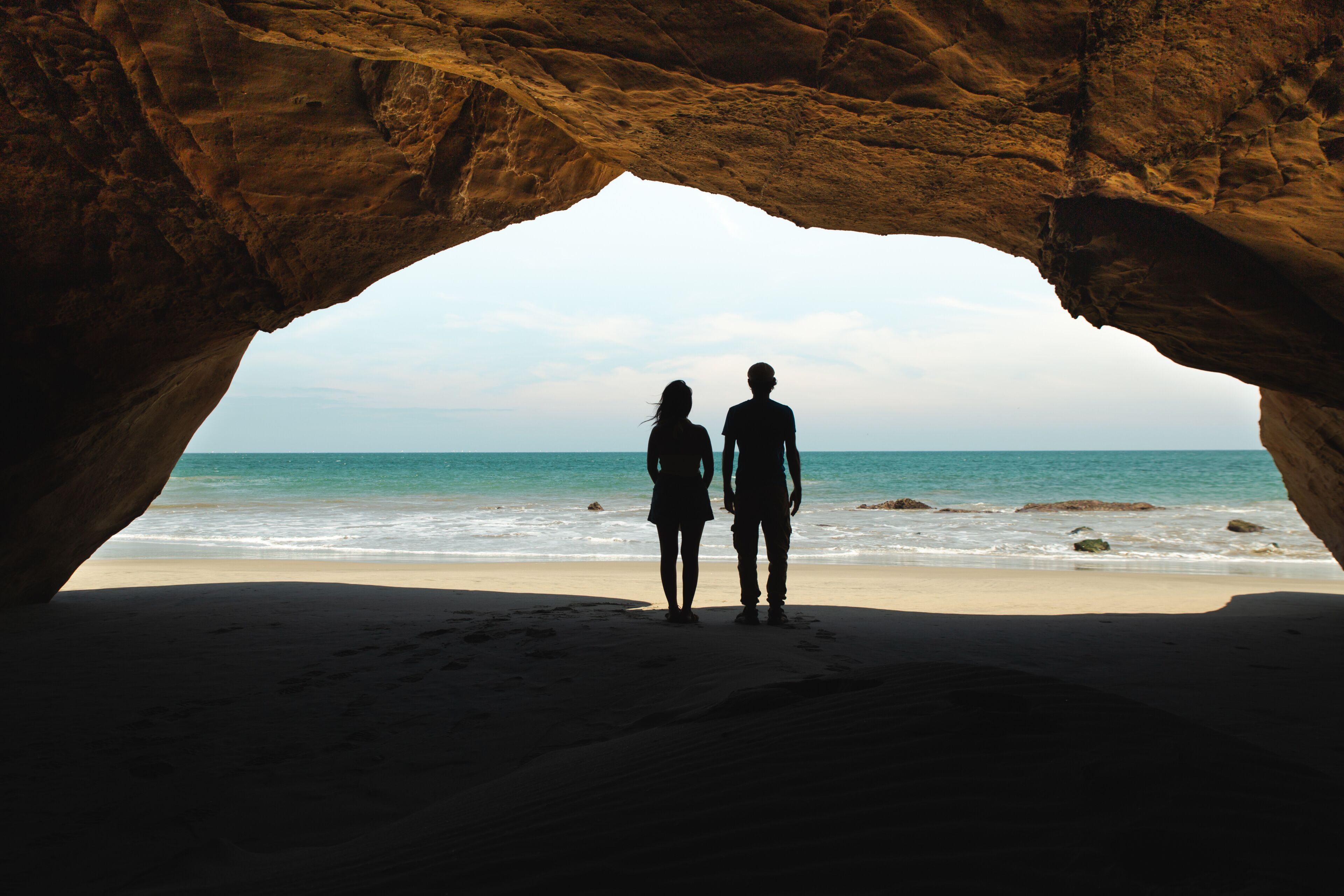 Romantic Couple Watching the Ocean from a Cave in Mancora, Peru
