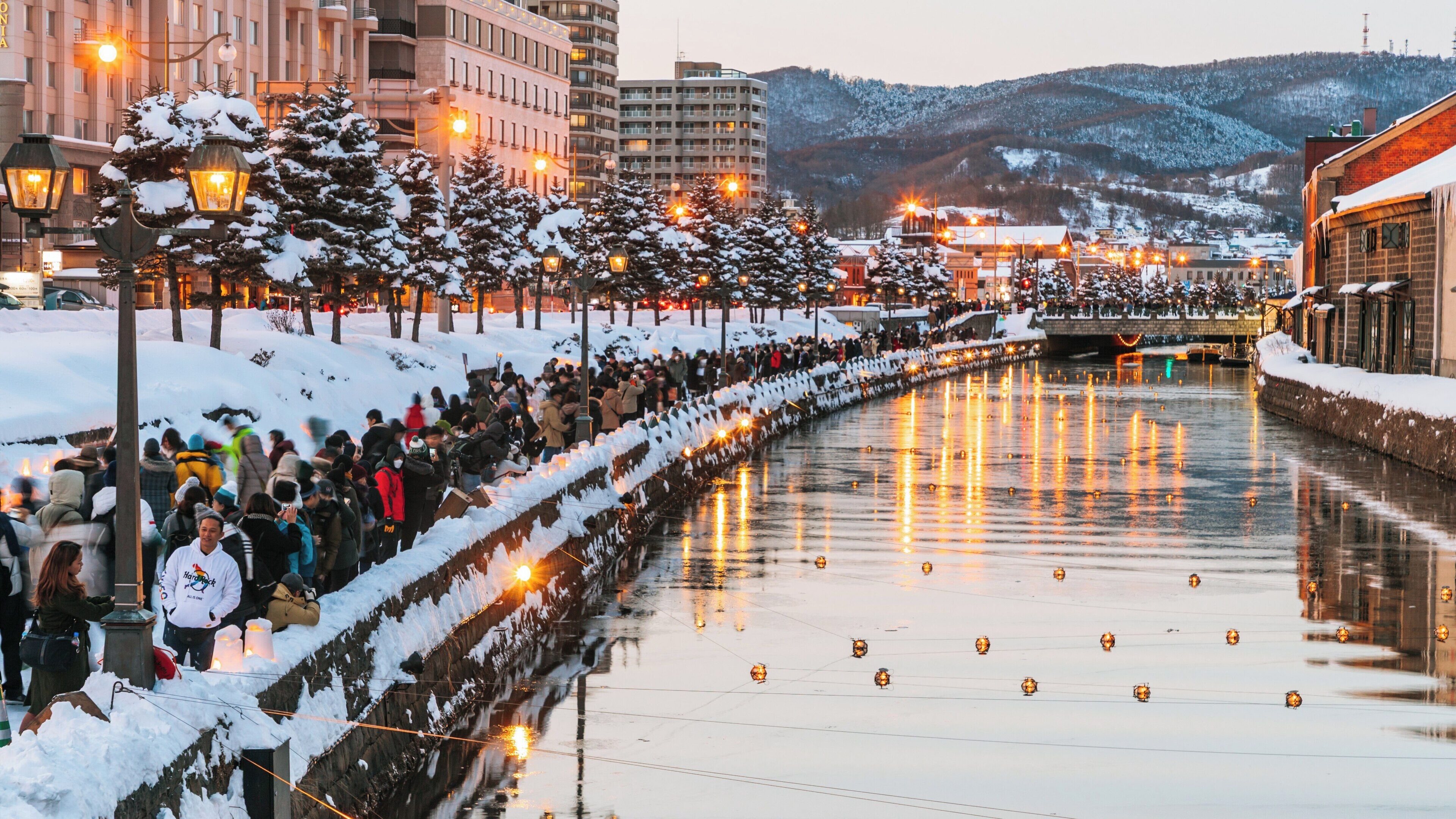 Stroll along Otaru Canal in Hokkaido during winter evening with lanterns illuminating the water