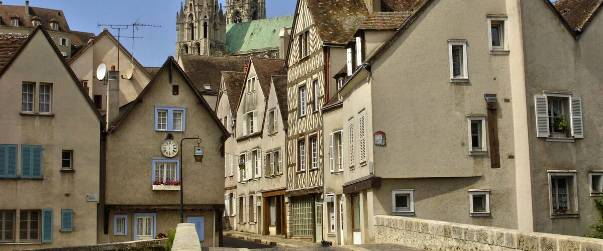 A historic European town with traditional half-timbered houses, a prominent church with twin spires, and cobblestone streets.