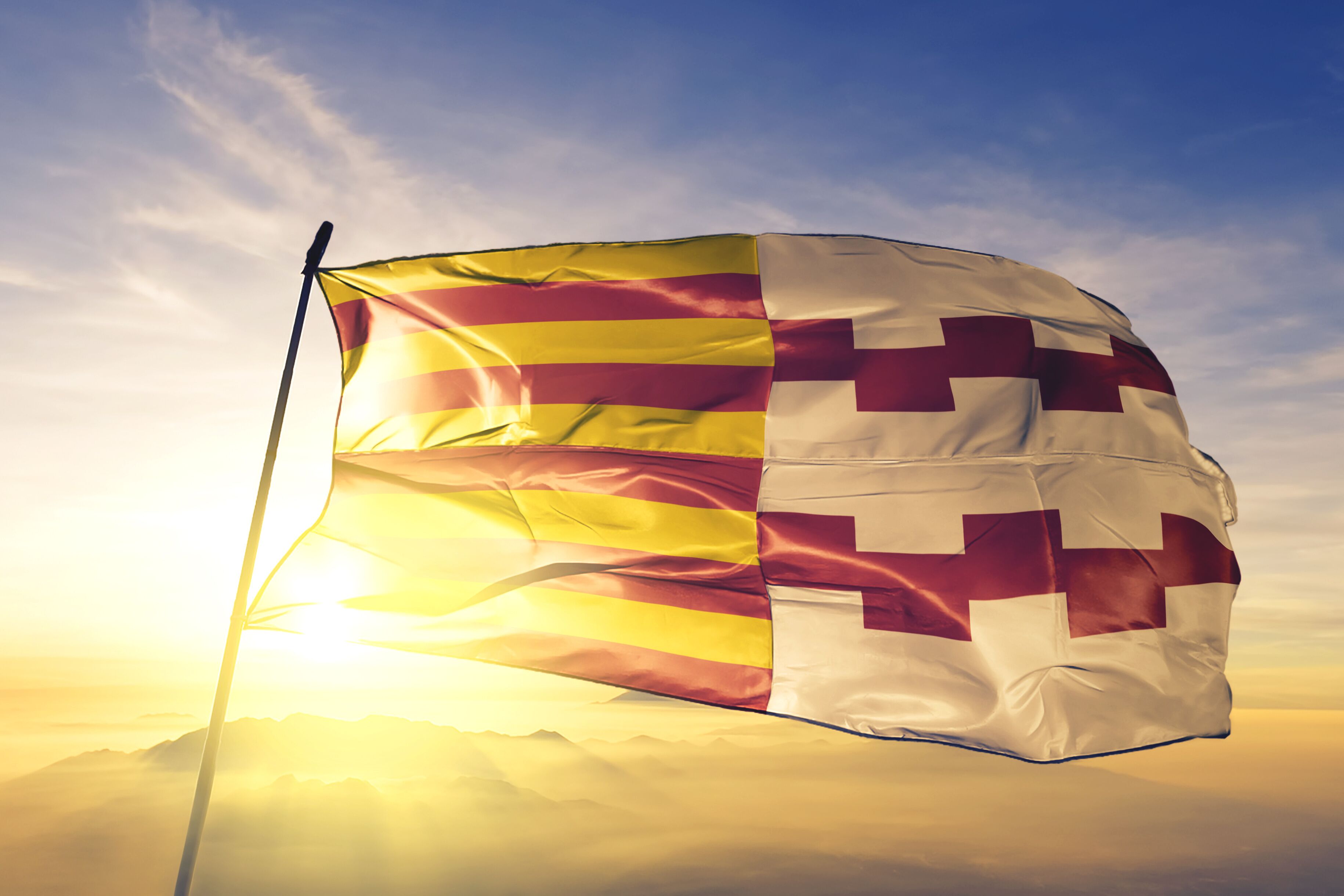 Hamont-Achel of Limburg of Belgium flag waving on the top sunrise mist fog