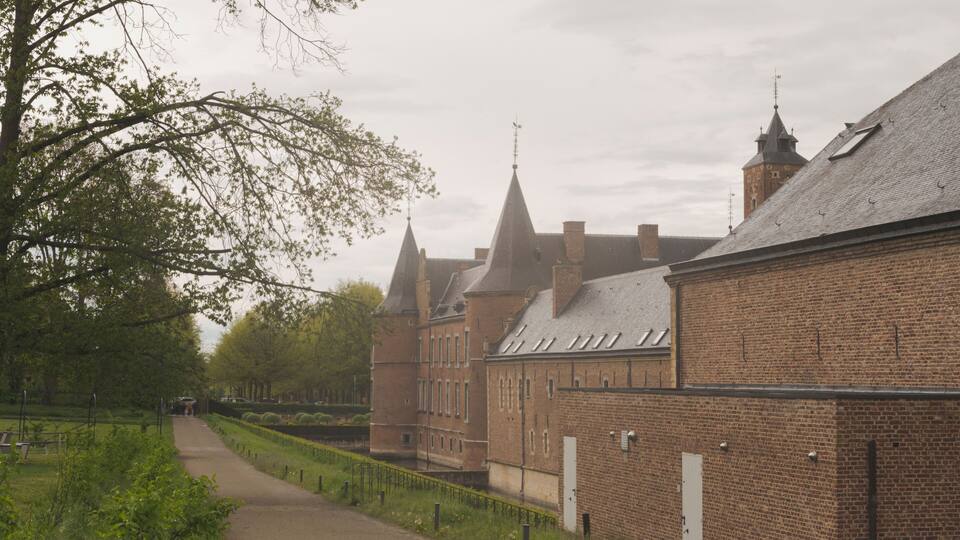 A brick building with multiple spires and a pathway leading to it.