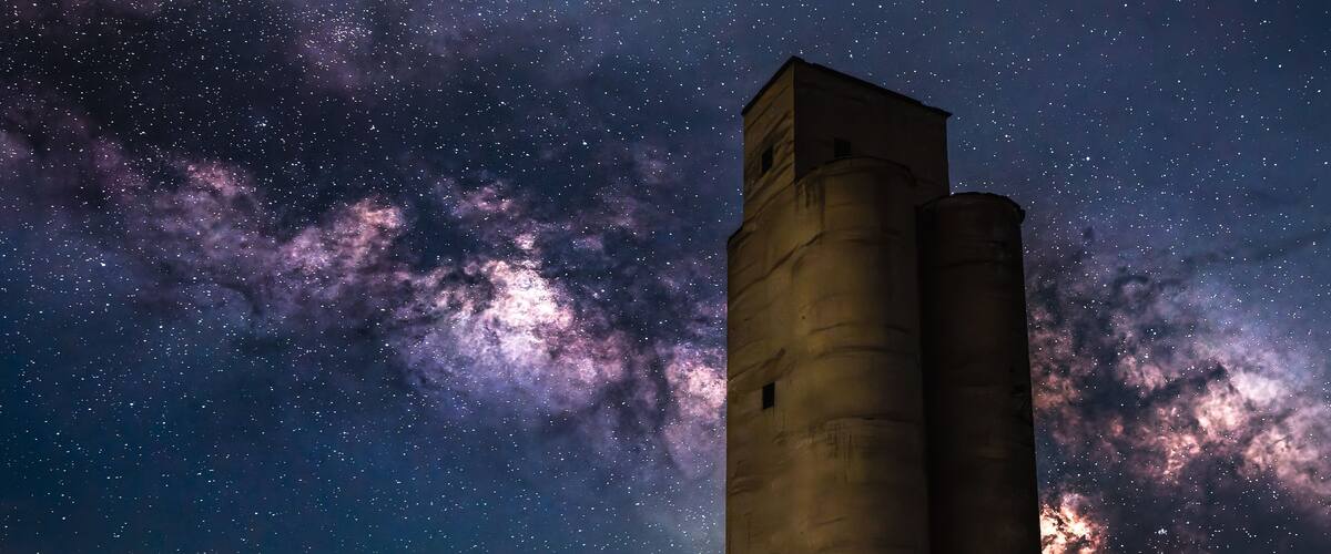 A tall tower under a starry night sky with the Milky Way visible.