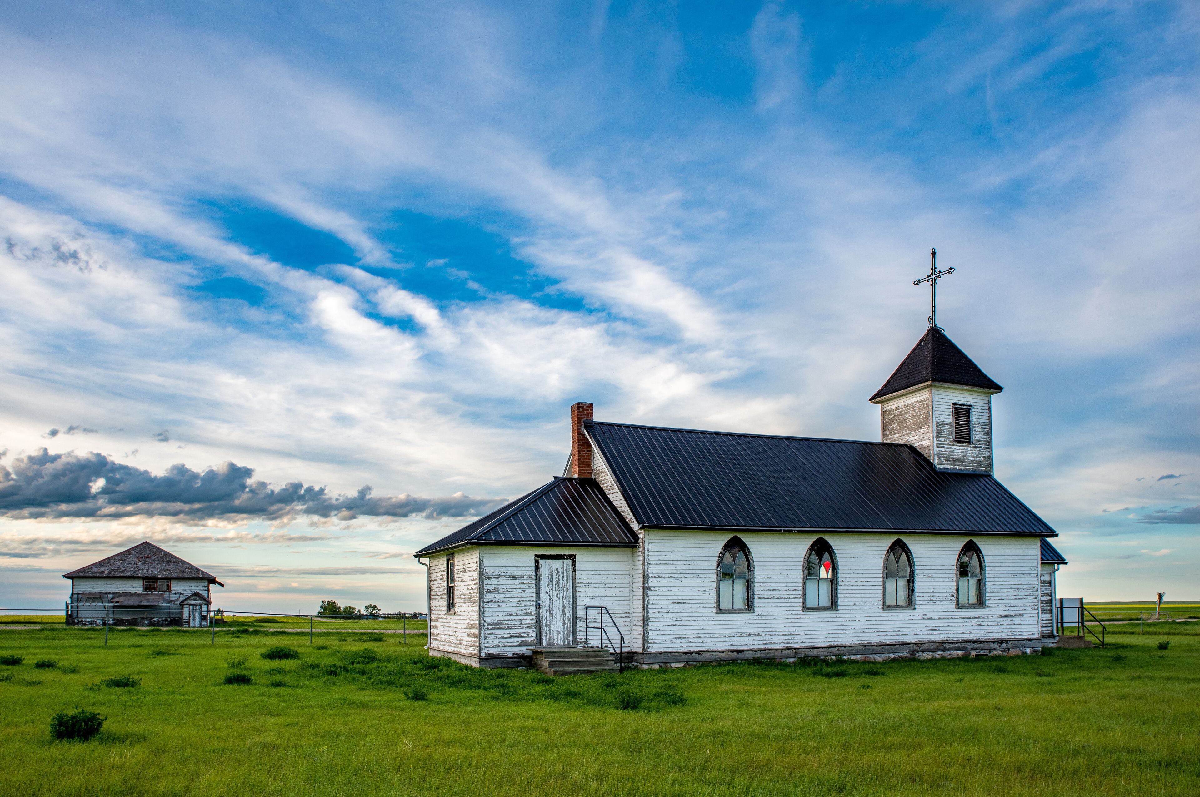 St. Marys Mission Church with the old Maxstone school in the background in Maxstone, SK