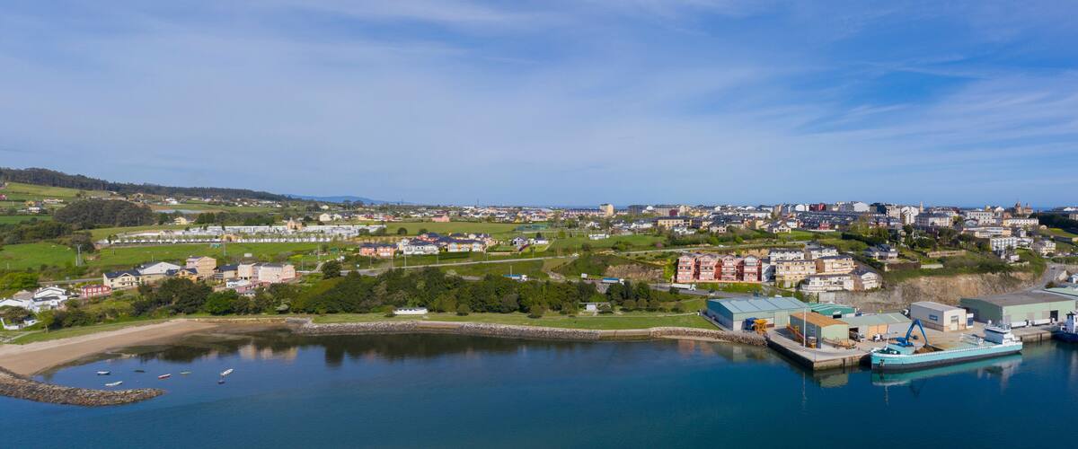 A coastal town with a harbor, boats, and a mix of residential and commercial buildings.