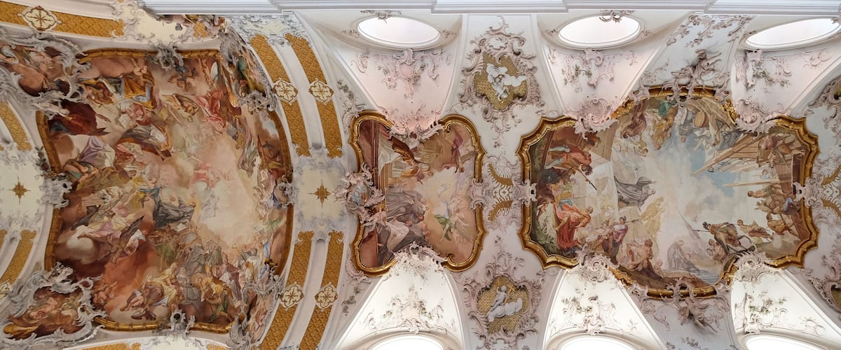 An ornate ceiling with elaborate frescoes and gold accents.